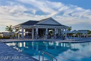 Expansive outdoor swimming pool with lane lines, surrounded by a paved deck
