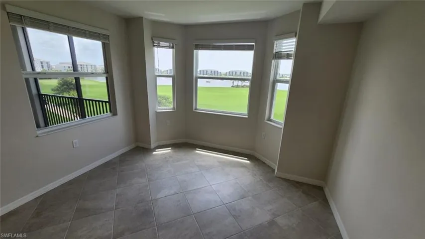 Room featuring a bay window with multiple panes, overlooking a water feature and green space