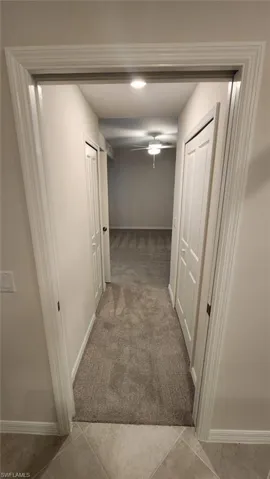 Hallway featuring recessed lighting, light gray carpeting, and white paneled doors