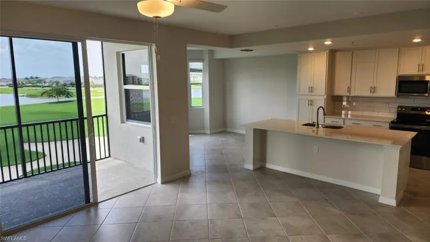 Open-concept living space featuring a gourmet kitchen with an island, a screened balcony, and tile flooring