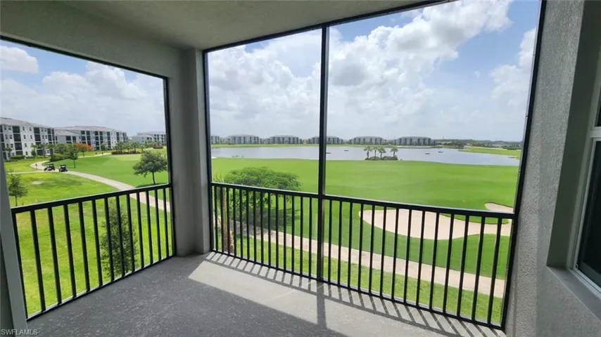 Screened balcony featuring a golf course and lake panorama