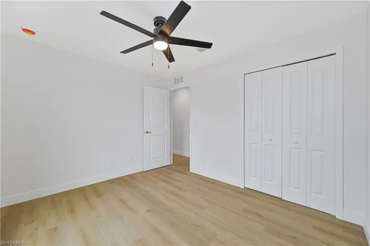 Unfurnished bedroom with light wood finished floors, a closet, and ceiling fan