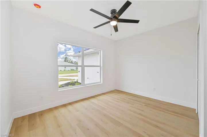 Empty room with light wood-style flooring and a ceiling fan
