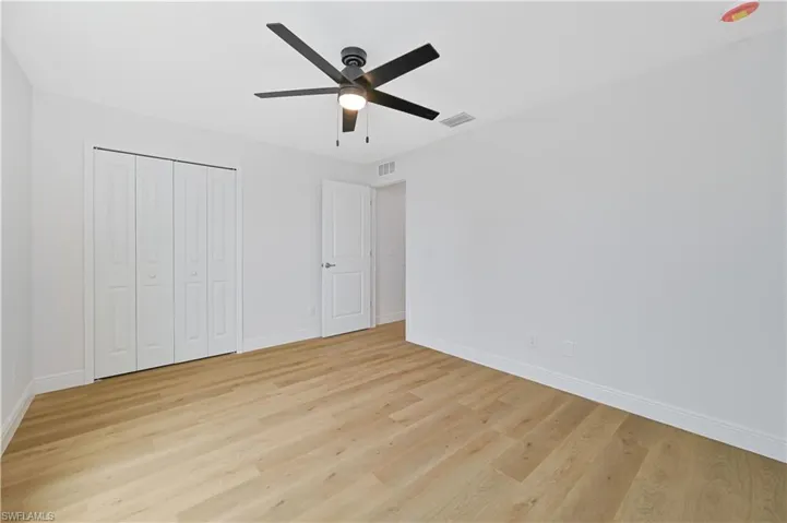Unfurnished bedroom featuring ceiling fan, light wood-type flooring, and a closet