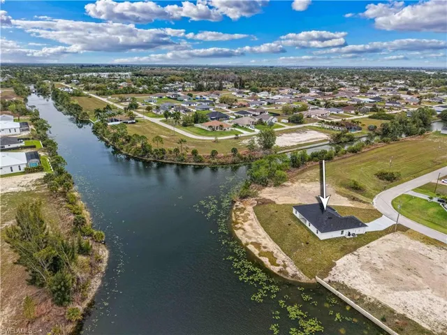 Aerial view of residential area featuring a nearby body of water