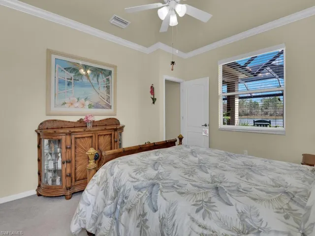 Bedroom featuring carpet, ceiling fan, and ornamental molding