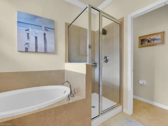 Bathroom featuring tile patterned floors, shower with separate bathtub, and crown molding