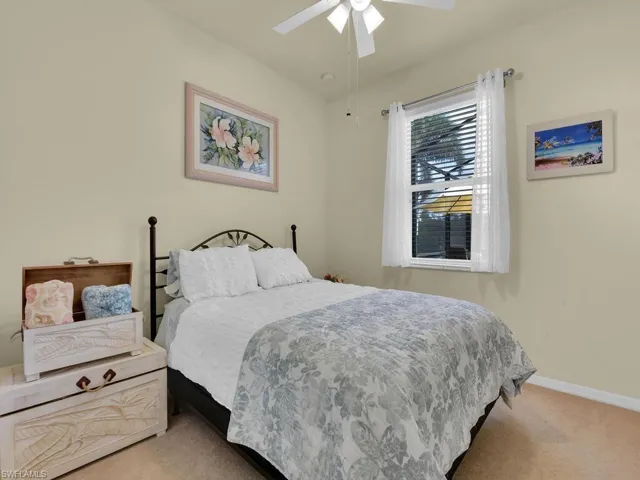 Carpeted bedroom featuring ceiling fan