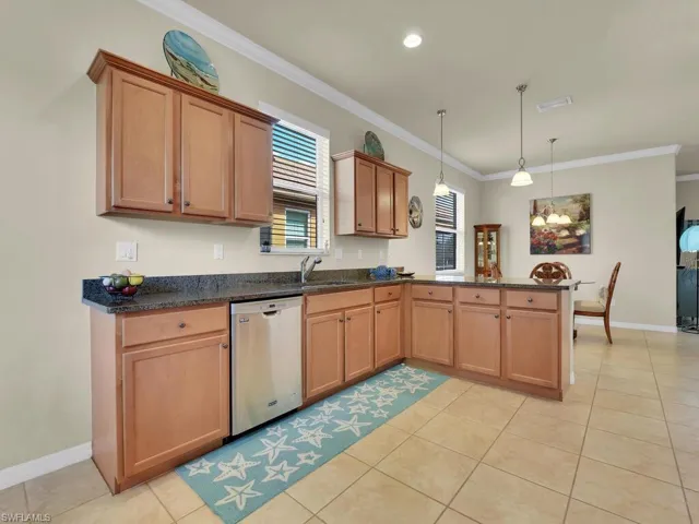 Kitchen with pendant lighting, dishwasher, crown molding, sink, and kitchen peninsula