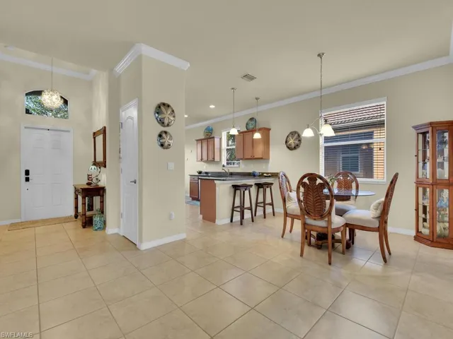 Tiled dining area with a chandelier and ornamental molding
