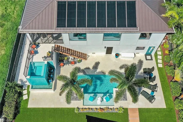 Aerial view of property and surrounding area featuring a pool