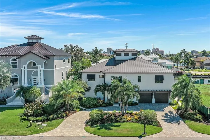 Coastal inspired home with decorative driveway, a garage, stucco siding, metal roof, and a standing seam roof