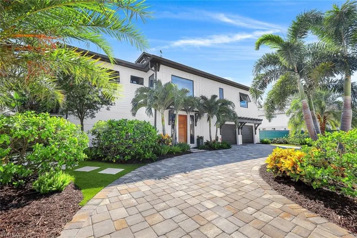 View of front facade featuring a garage and decorative driveway