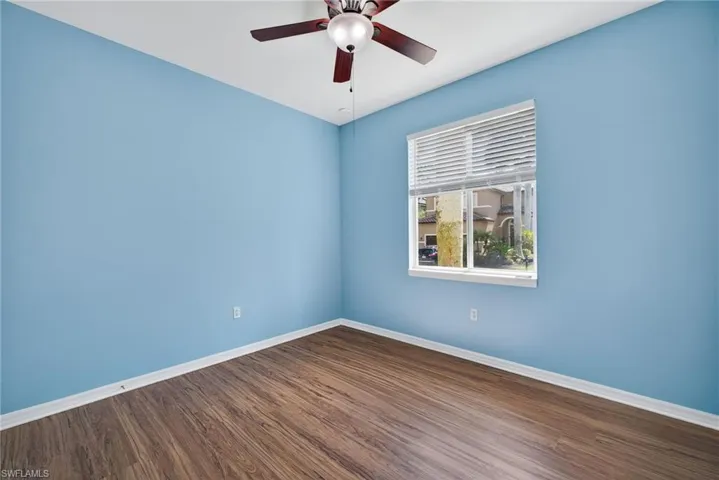 Spare room featuring dark wood finished floors and ceiling fan
