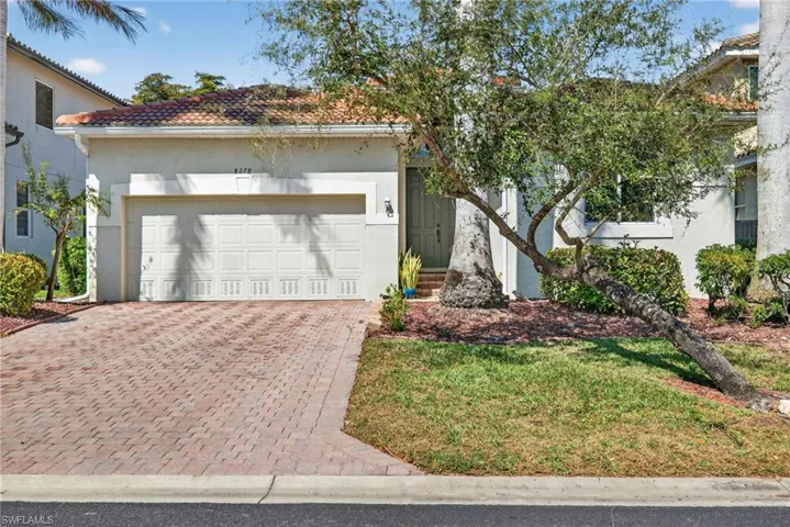 View of front of house featuring decorative driveway, stucco siding, a garage, and a tiled roof