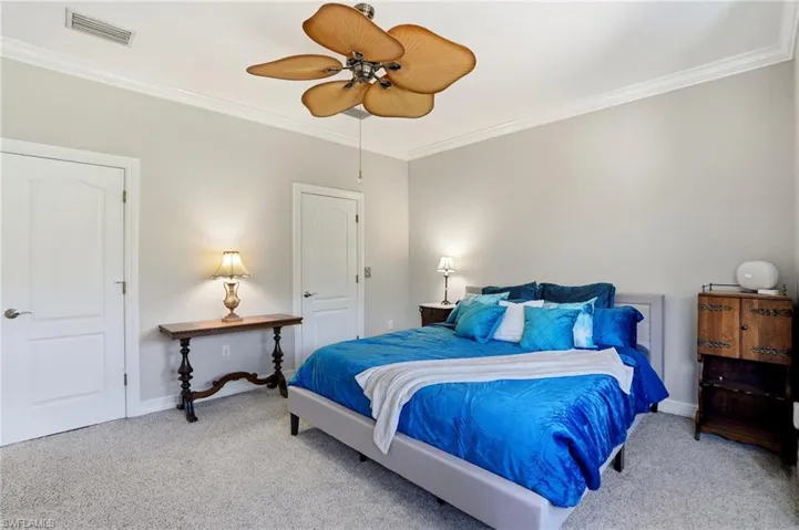 Bedroom with crown molding, carpet, and ceiling fan