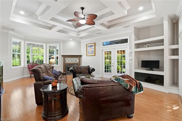 Kitchen with glass insert cabinets, stainless steel appliances, a breakfast bar area, backsplash, and dark stone countertops