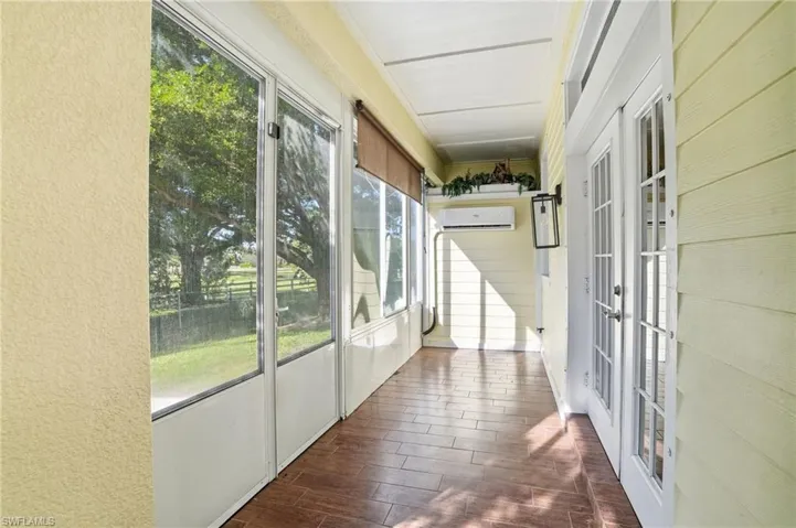 Unfurnished sunroom featuring french doors and a wall unit AC