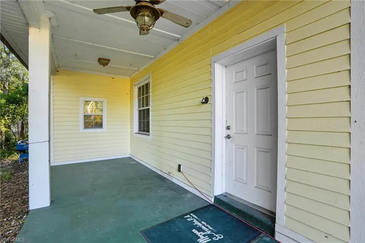 Doorway to property featuring a ceiling fan