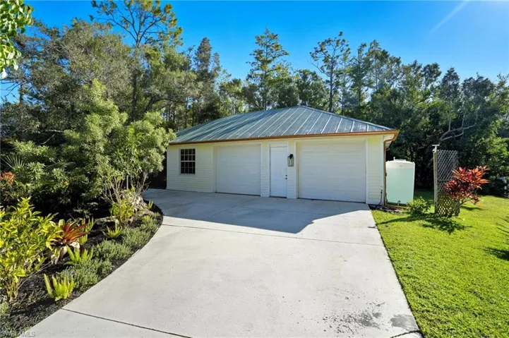 Detached garage featuring view of wooded area