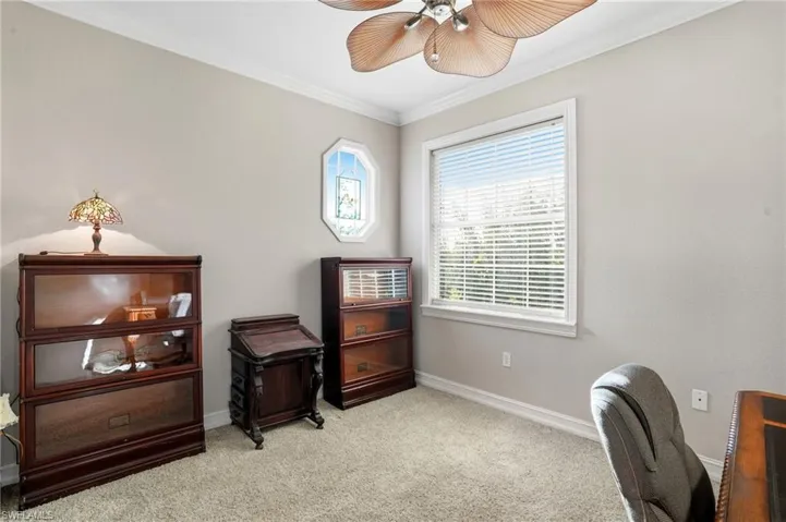 Office area featuring ornamental molding, light carpet, and ceiling fan