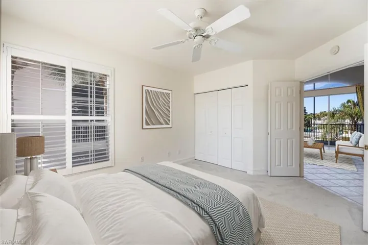 Bedroom with baseboards, a closet, a ceiling fan, and light colored carpet.  Virtual