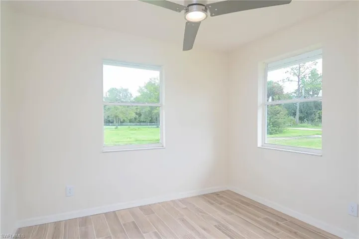 Unfurnished room with a wealth of natural light, light hardwood / wood-style flooring, and ceiling fan