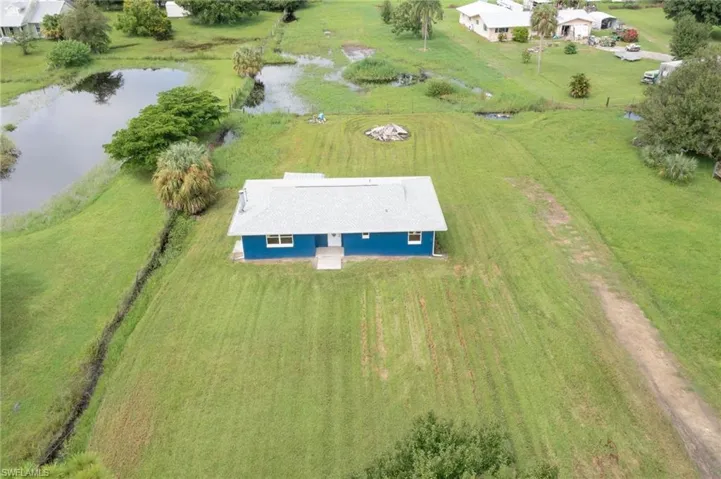 Birds eye view of property with a water view and a rural view