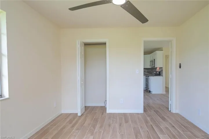 Unfurnished bedroom featuring ceiling fan, a closet, and light wood-type flooring