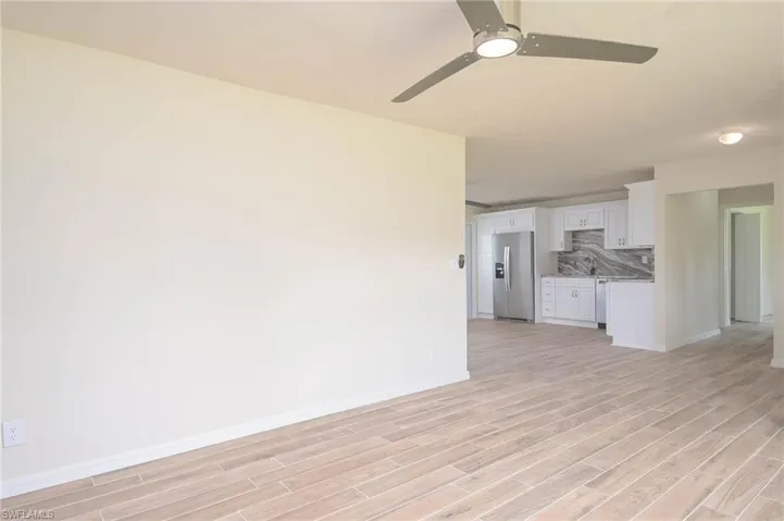 Unfurnished living room featuring light hardwood / wood-style flooring, sink, and ceiling fan