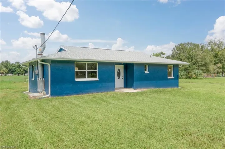 Back of property featuring a yard