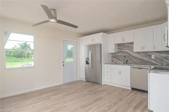Kitchen featuring white cabinetry, stainless steel appliances, light hardwood / wood-style flooring, and ceiling fan