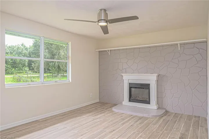 Unfurnished living room featuring ceiling fan and light wood-type flooring