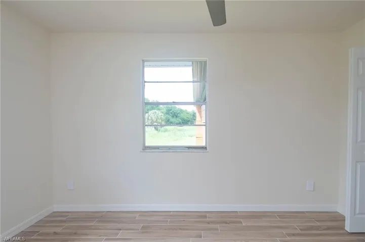 Spare room with light wood-type flooring and ceiling fan