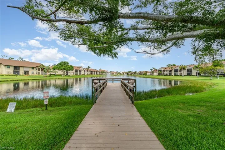 Dock area with a residential view, a yard, and a water view