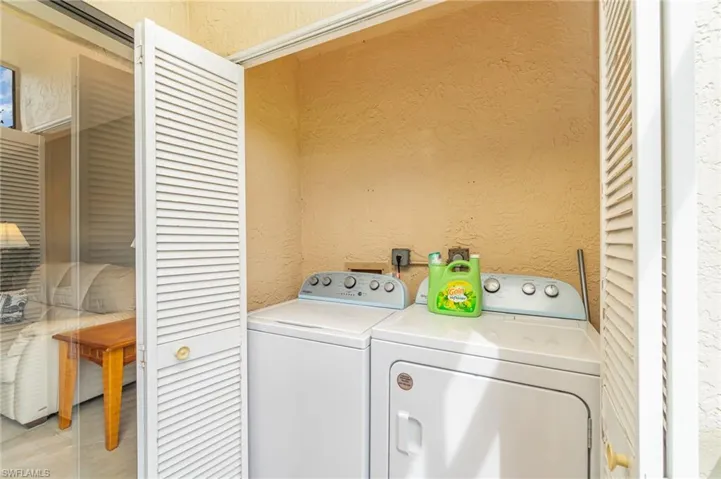 Laundry room with a textured wall and washer and dryer
