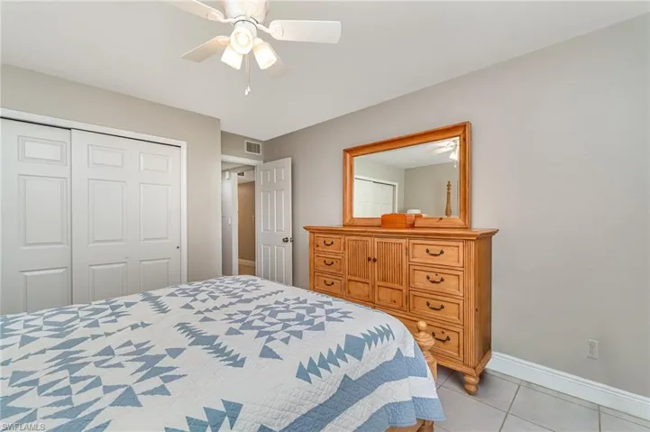 Bedroom with a ceiling fan, a closet, and light tile patterned floors
