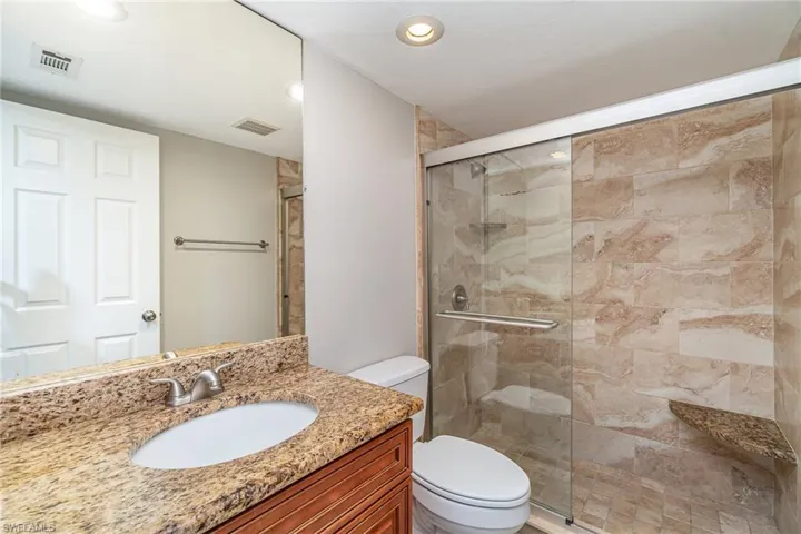Full bath featuring vanity, a shower stall, and recessed lighting
