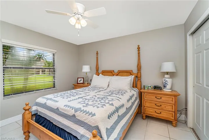 Bedroom with a closet, ceiling fan, and light tile patterned flooring