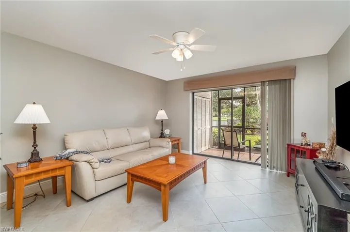 Living room with a ceiling fan and light tile patterned floors