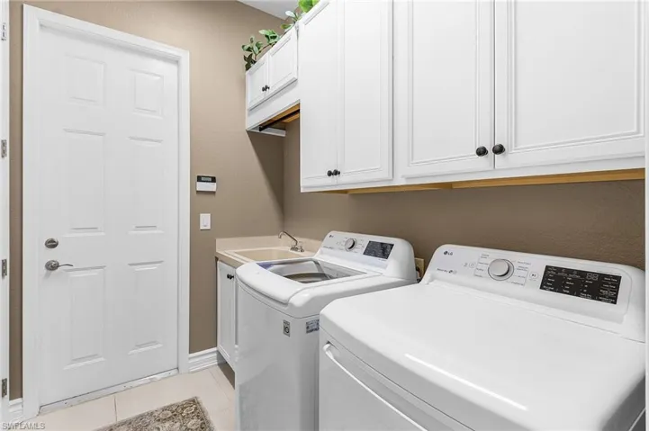 Laundry room with overhead cabinets and laundry sink