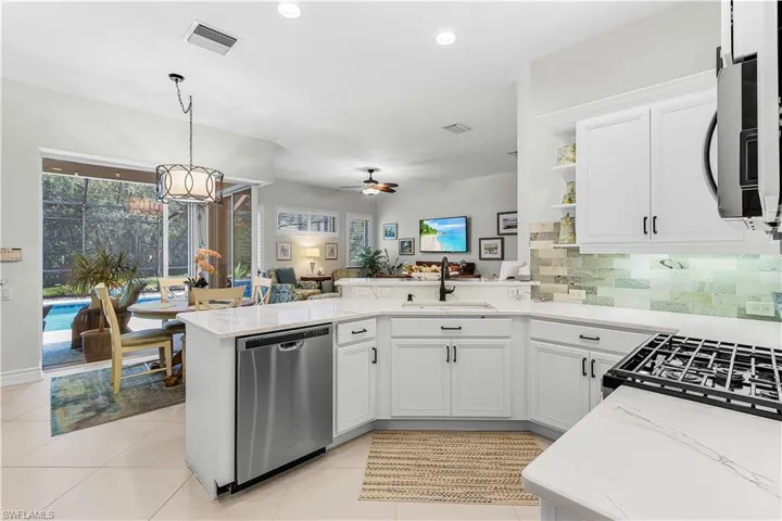 Kitchen featuring white cabinetry, hanging light fixtures, appliances with stainless steel finishes, a peninsula, and recessed lighting