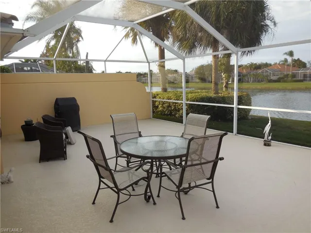 View of patio featuring a lanai and a water view