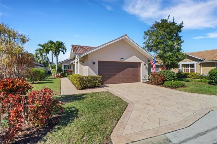 View of front of house with a garage and a front lawn