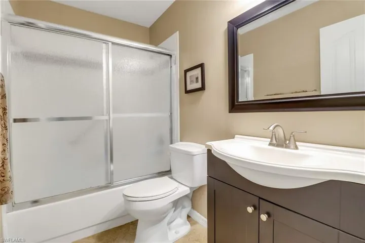Full bathroom with vanity, toilet, and combined bath / shower with glass door