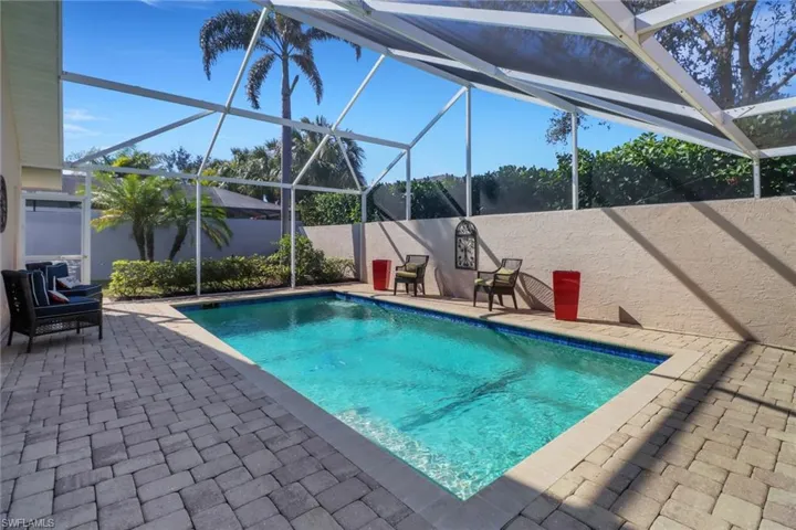 View of swimming pool with a patio and glass enclosure
