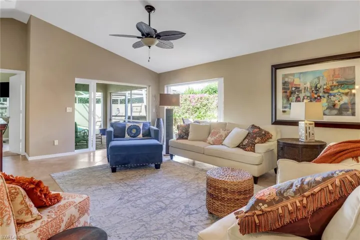 Living room featuring light tile patterned flooring, lofted ceiling, and ceiling fan