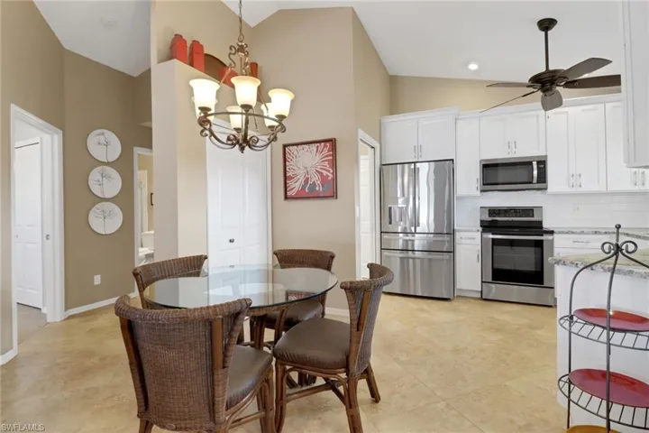 Dining room featuring lofted ceiling and ceiling fan with notable chandelier