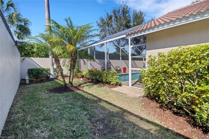View of yard featuring a fenced in pool and glass enclosure