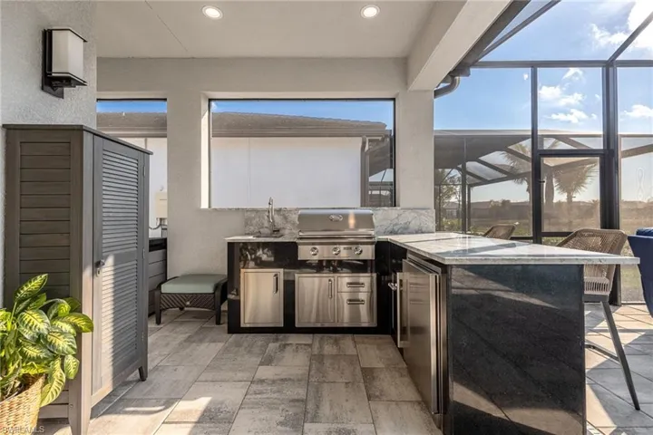 Outdoor Kitchen w/ grill, sink, refrigerator, and storage drawers